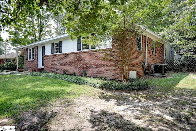 view of front of house with cooling unit and a front lawn