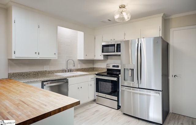 kitchen with crown molding, white cabinetry, sink, and stainless steel appliances