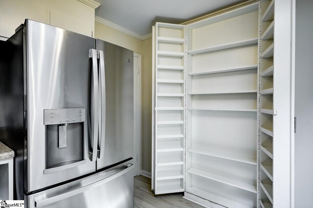 kitchen featuring light hardwood / wood-style flooring, ornamental molding, and stainless steel fridge with ice dispenser