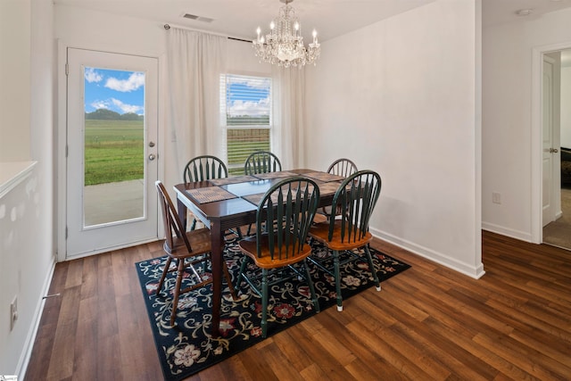 dining space featuring dark hardwood / wood-style flooring and a chandelier