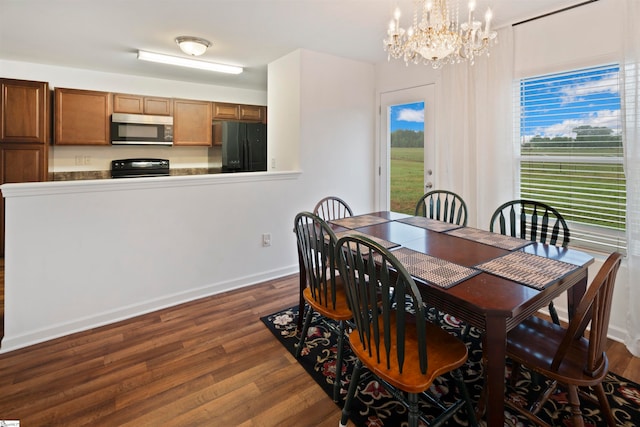 dining room featuring an inviting chandelier and dark wood-type flooring