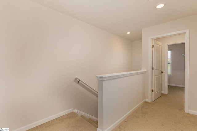 corridor featuring light colored carpet