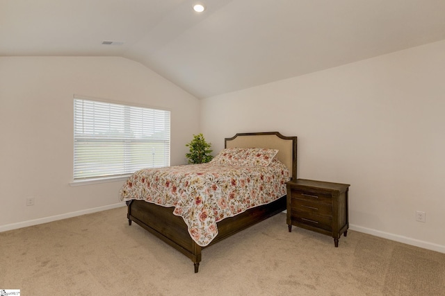 bedroom featuring light colored carpet and vaulted ceiling