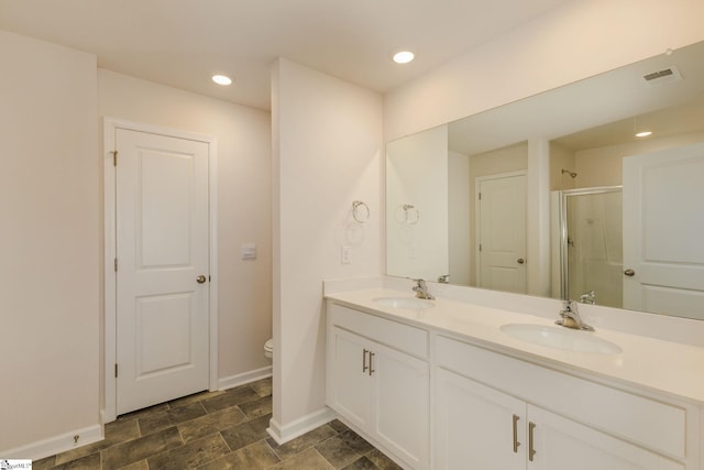 bathroom with walk in shower, vanity, and toilet