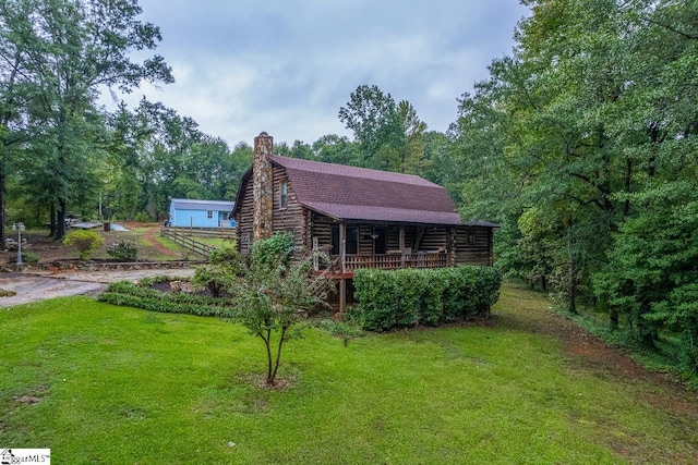 exterior space featuring a wooden deck and a front yard