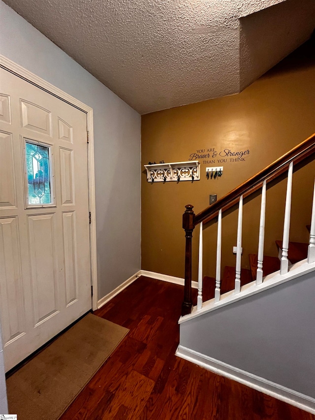 entryway with a textured ceiling and dark hardwood / wood-style floors