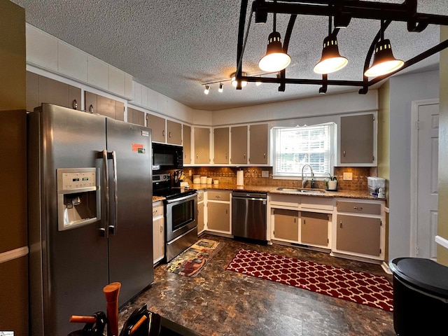 kitchen featuring a textured ceiling, sink, backsplash, and appliances with stainless steel finishes