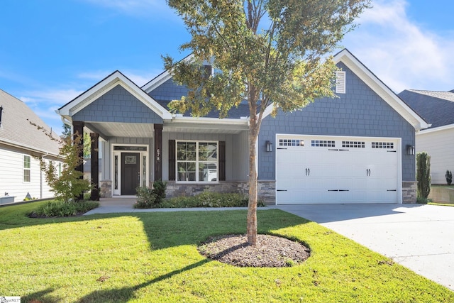 craftsman-style house featuring a front lawn, covered porch, and a garage