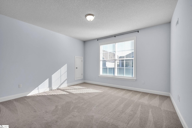 carpeted empty room featuring a textured ceiling