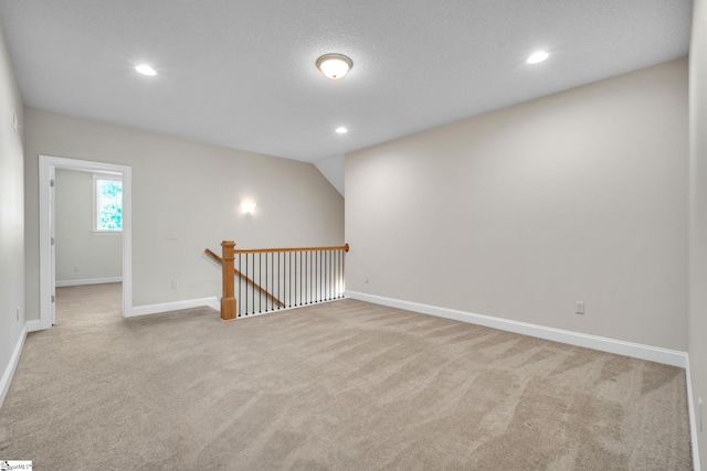 unfurnished room featuring light carpet and a textured ceiling