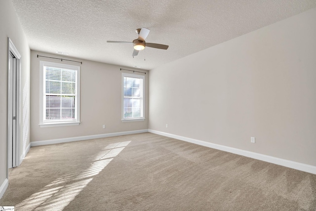 carpeted empty room featuring a textured ceiling and ceiling fan