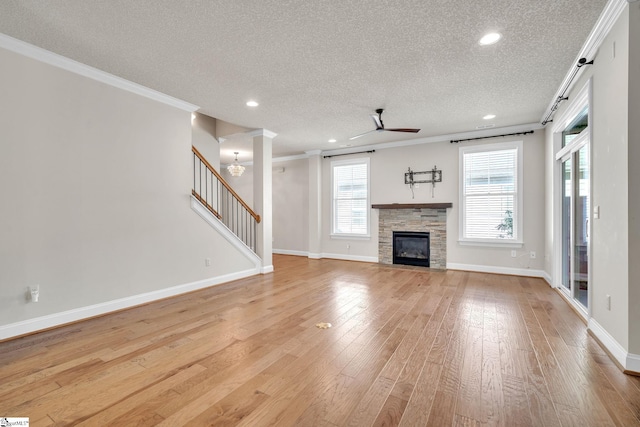 unfurnished living room with light hardwood / wood-style flooring, a textured ceiling, and a healthy amount of sunlight