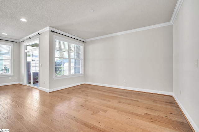 empty room featuring ornamental molding, light wood-type flooring, and a textured ceiling