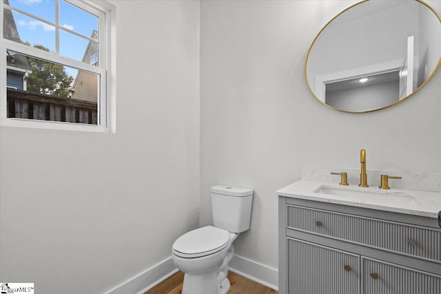 bathroom featuring wood-type flooring, vanity, and toilet