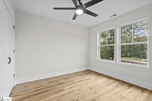 empty room with ceiling fan and light hardwood / wood-style flooring