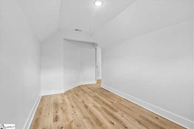 additional living space with vaulted ceiling and light hardwood / wood-style floors