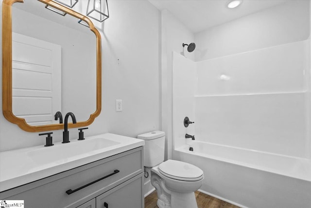 full bathroom with  shower combination, hardwood / wood-style flooring, vanity, and toilet