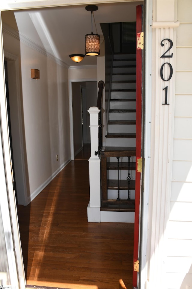 staircase with crown molding and wood-type flooring