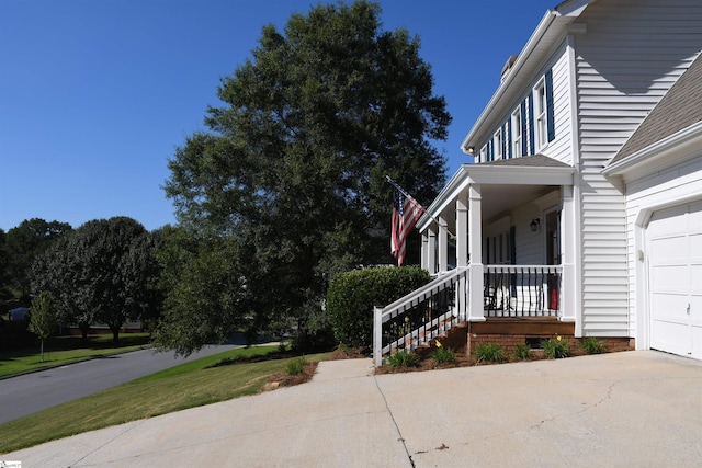 view of home's exterior with a garage and a porch