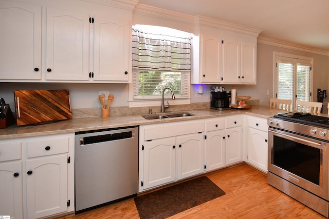 kitchen with white cabinetry, light hardwood / wood-style floors, appliances with stainless steel finishes, and crown molding