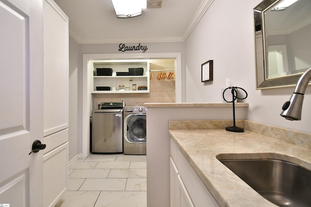 clothes washing area featuring ornamental molding, sink, and washer and dryer