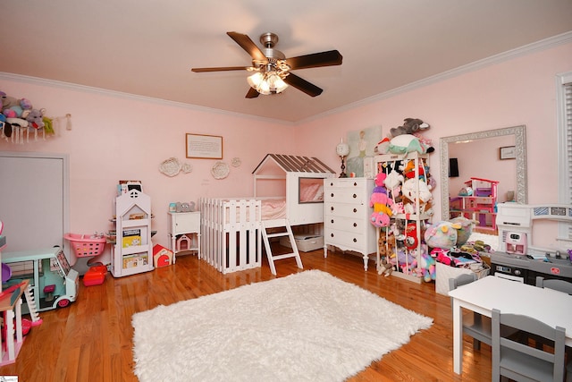 bedroom with ornamental molding, ceiling fan, and hardwood / wood-style floors