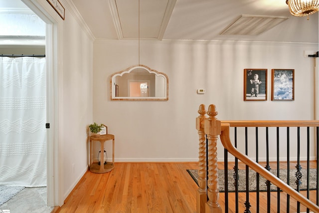 corridor with ornamental molding and hardwood / wood-style floors