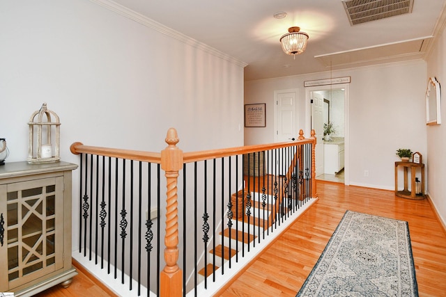 hall with hardwood / wood-style flooring and crown molding