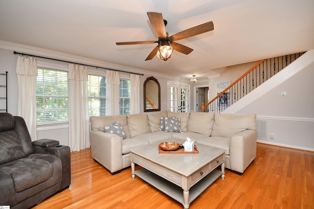 living room featuring ceiling fan, light wood-type flooring, and crown molding