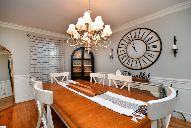 dining space with ornamental molding, light hardwood / wood-style flooring, and a chandelier