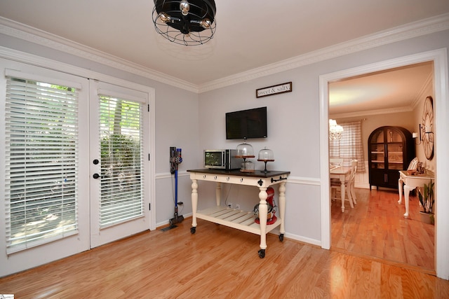 doorway to outside with ornamental molding, an inviting chandelier, and hardwood / wood-style floors