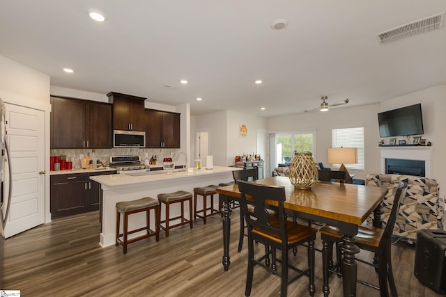 dining area with sink, dark wood-type flooring, and ceiling fan