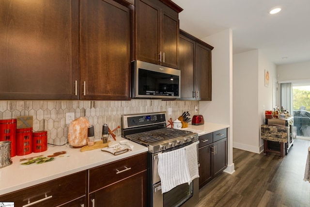 kitchen featuring dark brown cabinets, stainless steel appliances, backsplash, and dark hardwood / wood-style floors