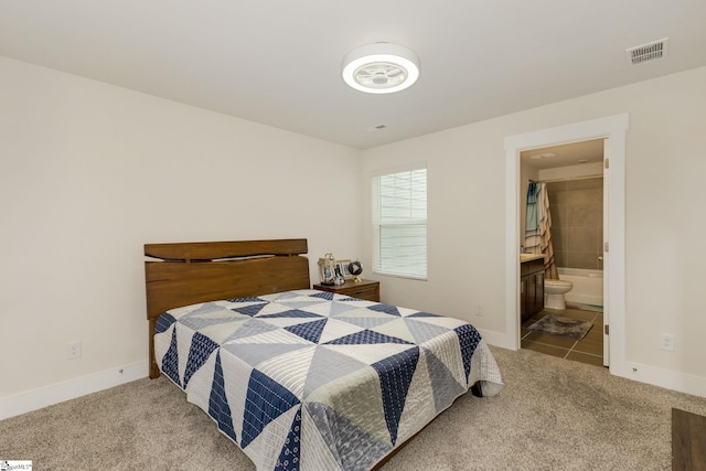 bedroom with ensuite bath and light colored carpet