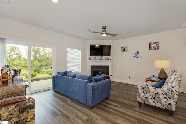 living room featuring ceiling fan and dark hardwood / wood-style floors