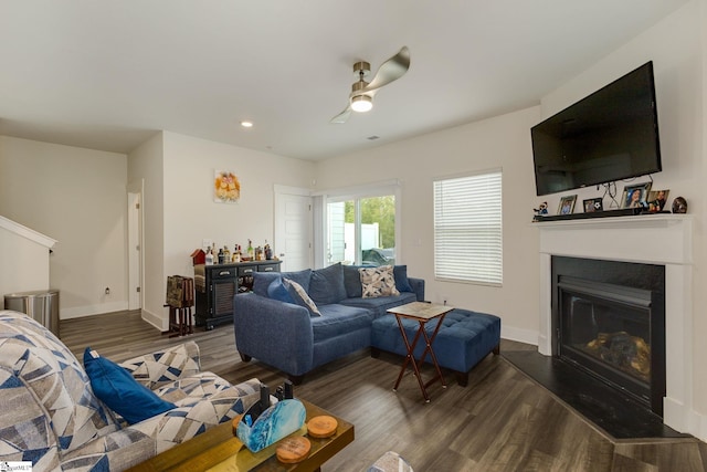 living room featuring ceiling fan and dark hardwood / wood-style flooring