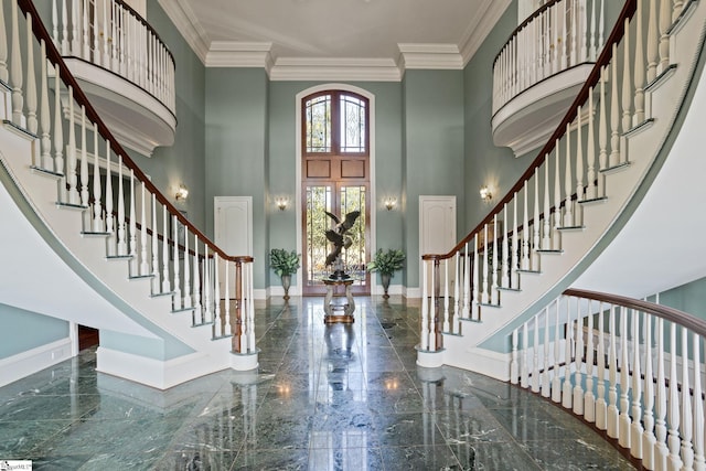 foyer entrance featuring ornamental molding and a towering ceiling