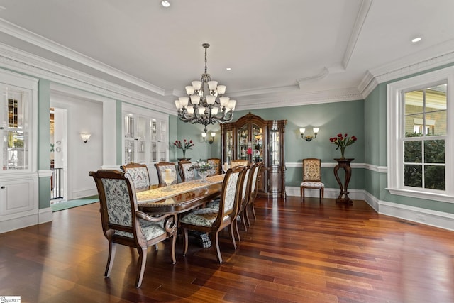 dining room with an inviting chandelier, crown molding, and dark hardwood / wood-style floors