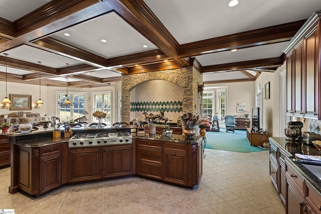 kitchen featuring stainless steel gas stovetop, decorative light fixtures, beamed ceiling, and a wealth of natural light