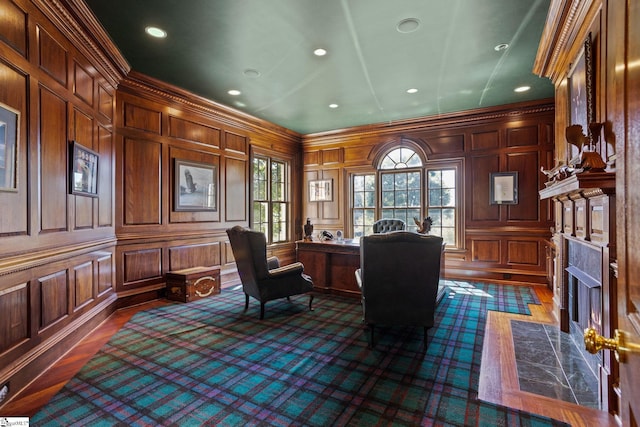 office space with a premium fireplace, wood walls, ornamental molding, and dark hardwood / wood-style flooring