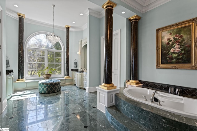 bathroom with vanity, decorative columns, and a relaxing tiled tub