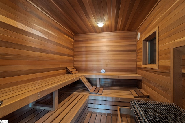 view of sauna / steam room featuring wooden ceiling and wooden walls