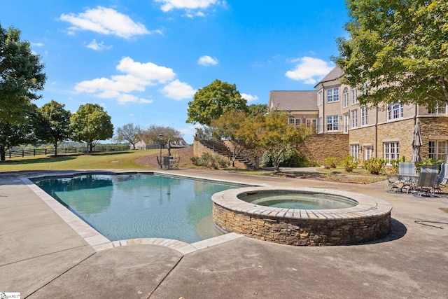 view of pool featuring a patio and an in ground hot tub