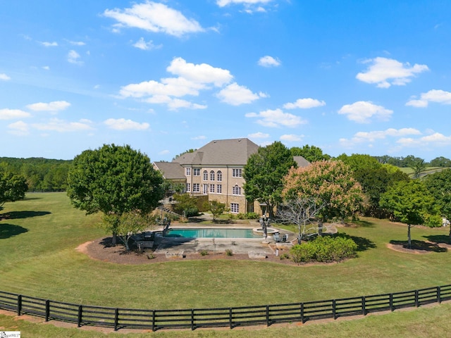 view of home's community with a rural view, a pool, and a yard