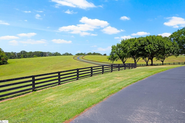 view of gate featuring a lawn and a rural view