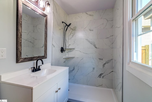 bathroom featuring a tile shower and vanity