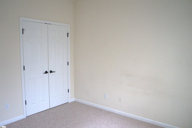 unfurnished bedroom featuring carpet flooring and a closet