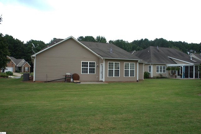 rear view of house with a lawn, cooling unit, and a patio