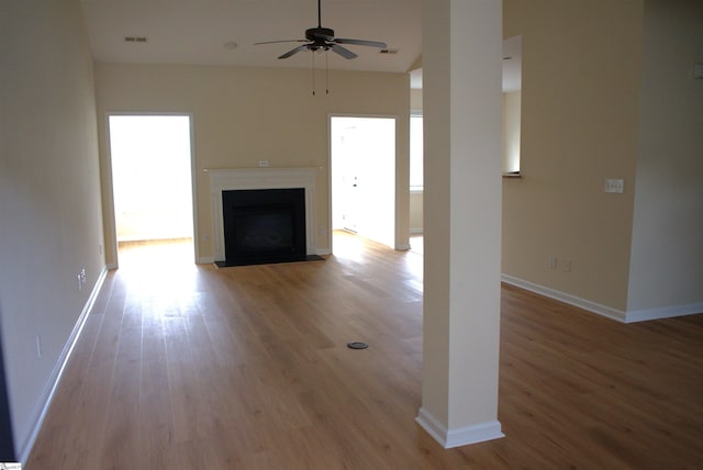 unfurnished living room with ceiling fan and light wood-type flooring