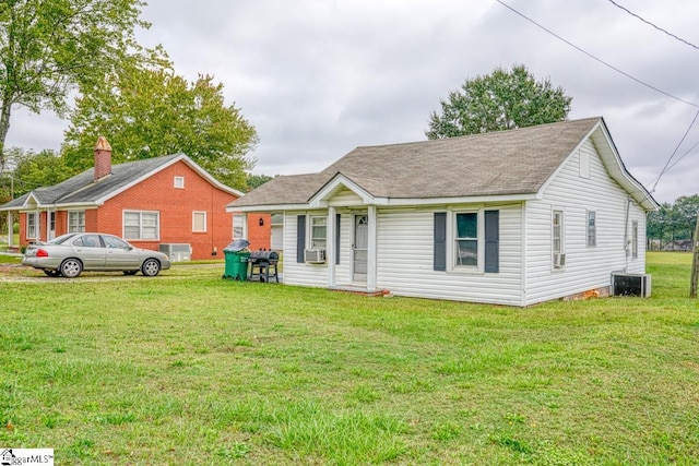 view of front of house featuring cooling unit and a front lawn